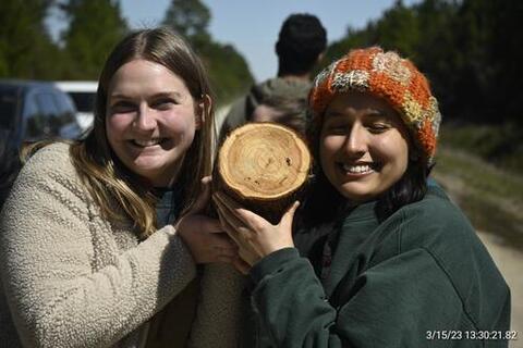 Diana Satkauskas '24 MF (left) and Amelia Napper '24 MF examine pulp wood in NC State University's Hofmann Forest. Photo by: Brandon Wilson Radcliffe ‘24 MF.